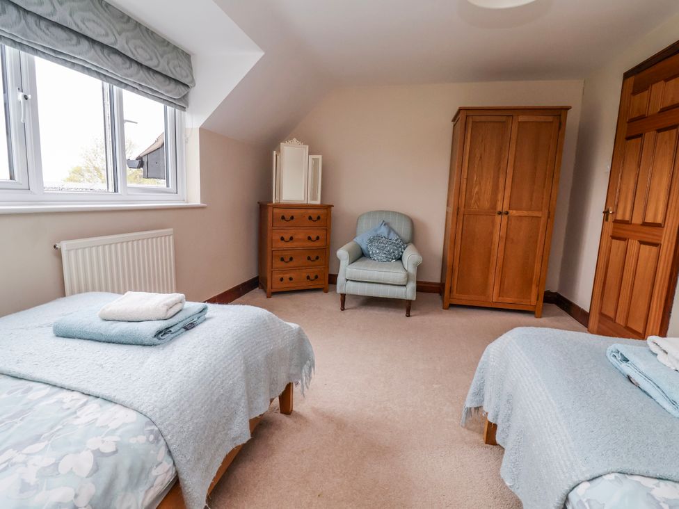 A bedroom with twin beds and wooden furniture at Manor Wood Farndon