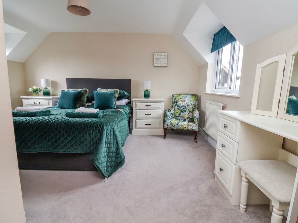 A bedroom with a bed and dresser at Manor Wood in Farndon