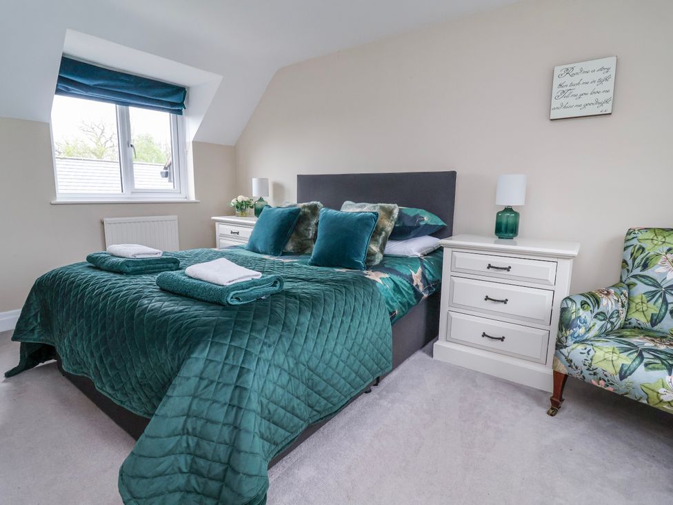 A bedroom with a bed and nightstand at Manor Wood in Farndon