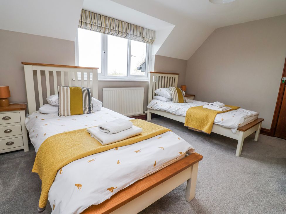 A bedroom with two beds and a radiator at Manor Wood in Farndon