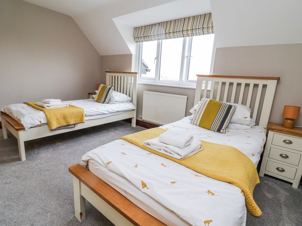 A bedroom with two beds and a bedside table at Manor Wood in Farndon