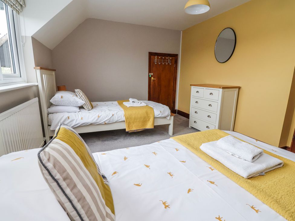 A bedroom with two beds and a dresser at Manor Wood in Farndon