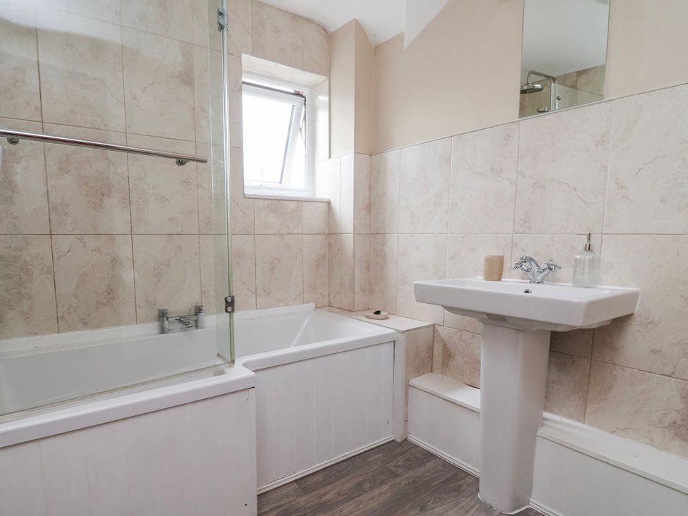 A bathroom with a bathtub and sink at Manor Wood in Farndon