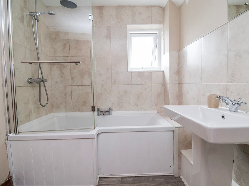 A bathroom with a bathtub and sink at Manor Wood Farndon