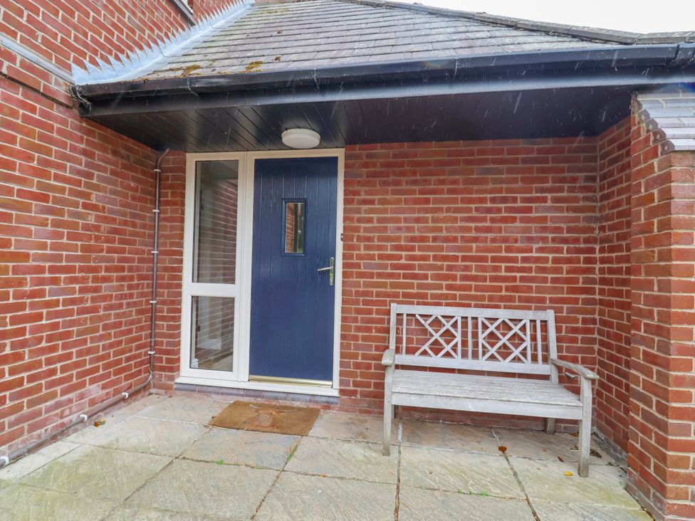 An entrance area with a blue door and a bench at Manor Wood Farndon