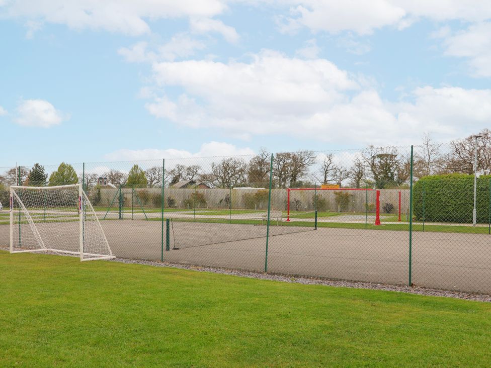 An outdoor area with a soccer goal and tennis net at Manor Wood in Farndon