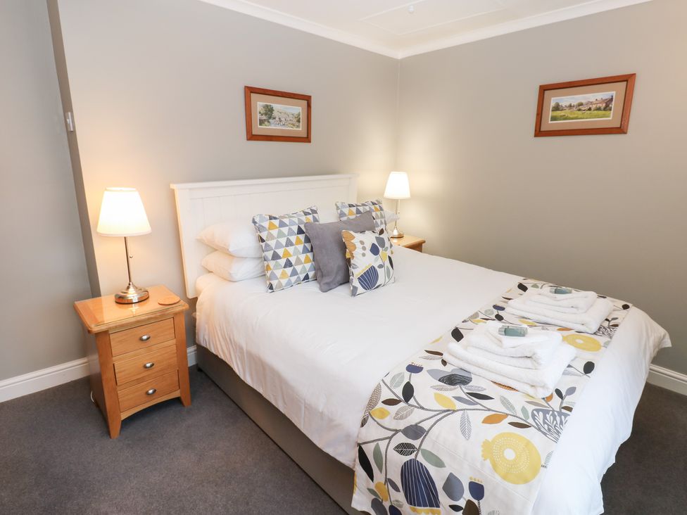A bedroom with a bed and bedside tables at Braeside Reeth