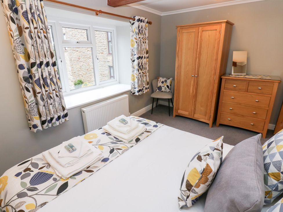 A bedroom with a bed and furniture at Braeside in Reeth