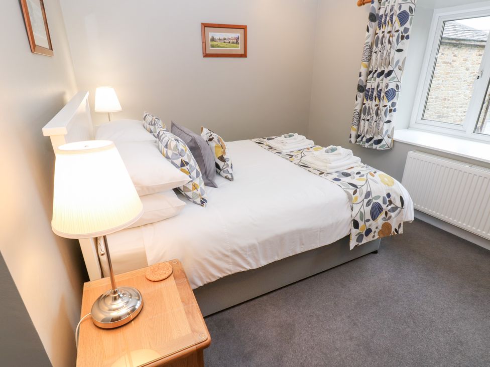 A bedroom with a bed and lamp at Braeside Reeth