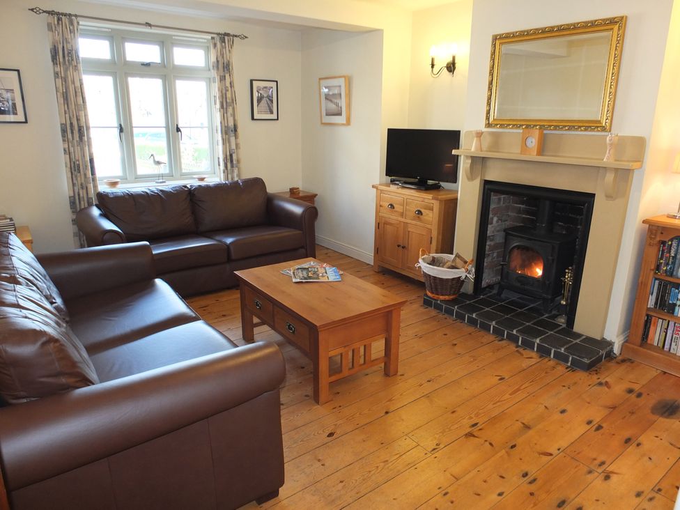 A living room with a sofa and a coffee table at COO - Beaconsfield Cottage in Melton Constable