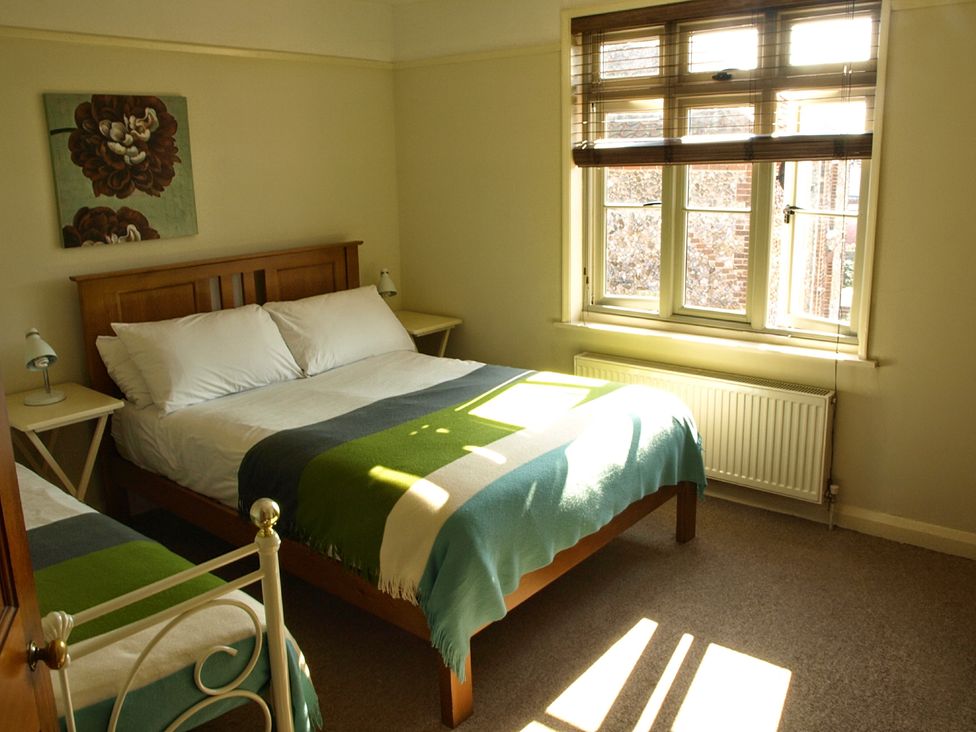 A bedroom with two beds and a window at COO - Beaconsfield Cottage Melton Constable