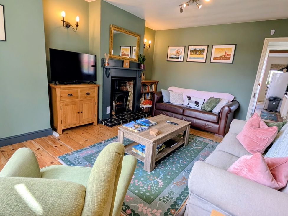 A living room with a television and sofa at Beaconsfield Cottage in Briston
