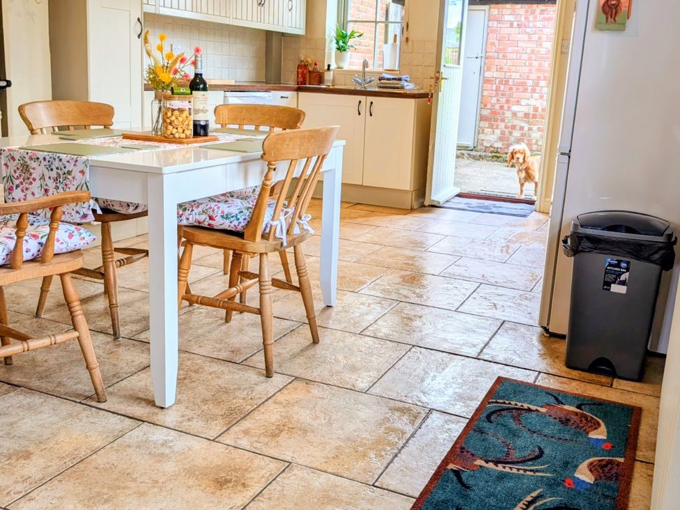 A kitchen with a table and chairs at Beaconsfield Cottage in Briston