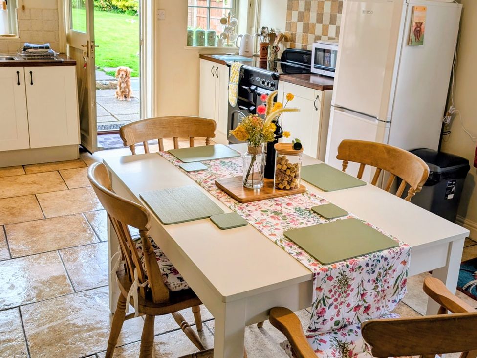 A kitchen with a dining table and chairs at Beaconsfield Cottage in Briston