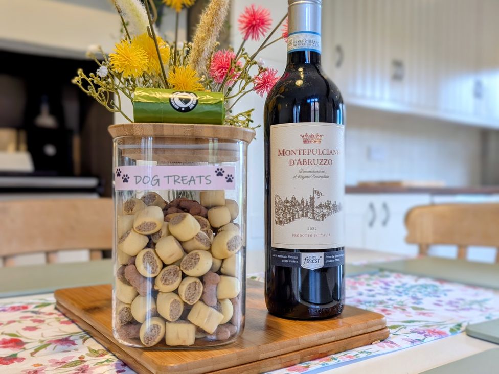 A kitchen with a jar of dog treats and a bottle of wine at Beaconsfield Cottage in Briston