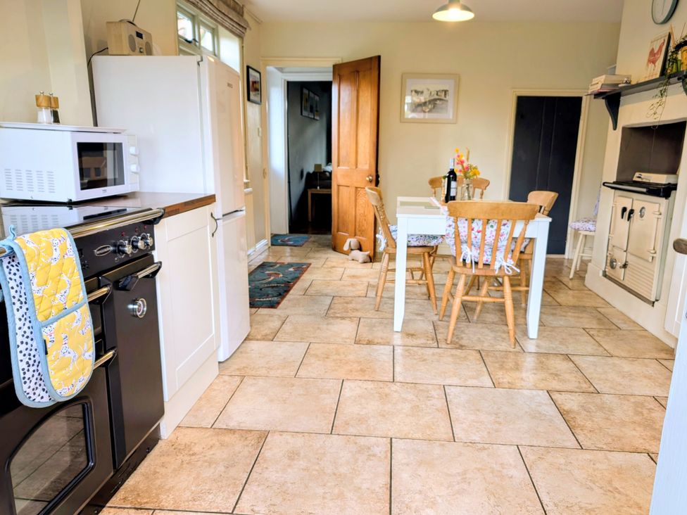 A kitchen with an oven and a table at Beaconsfield Cottage in Briston