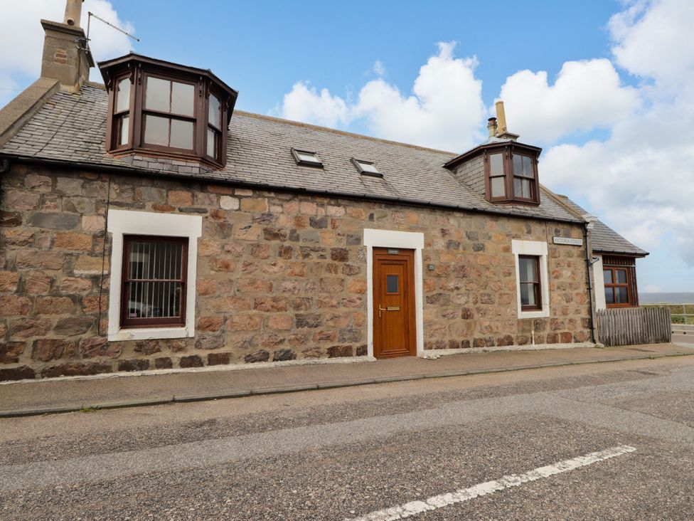 A stone house with multiple windows and a door at Seascape in Portknockie