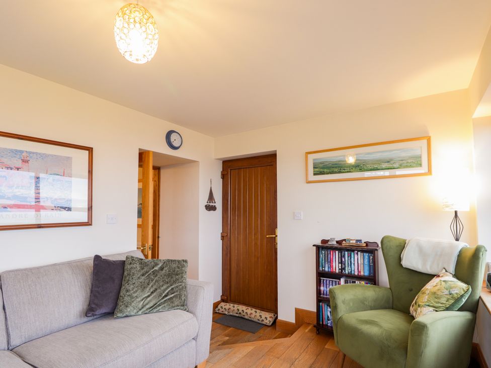 A living room with a sofa and bookshelf at Seascape in Portknockie