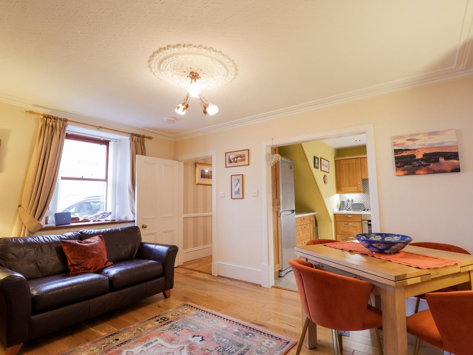 A living room with a sofa and dining table at Seascape in Portknockie