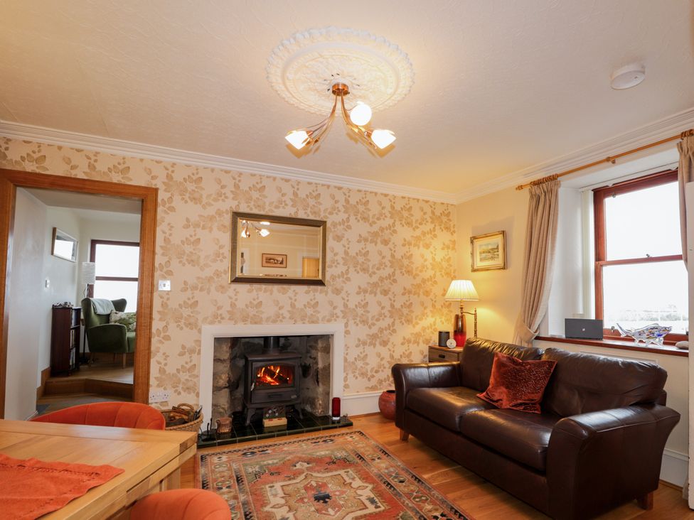 A living room with a fireplace and a sofa at Seascape in Portknockie