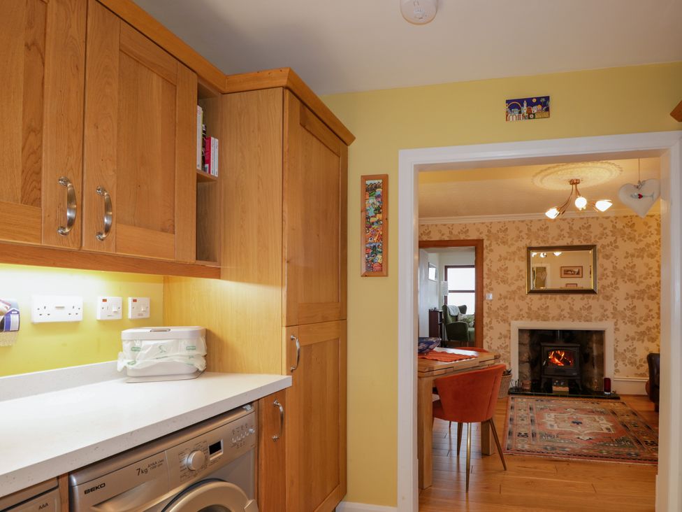 A kitchen with a washing machine and a doorway to a living room at Seascape in Portknockie