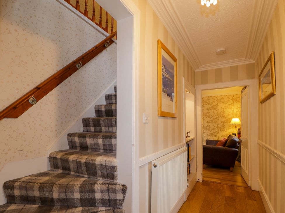 A hallway with stairs and a doorway to a living area at Seascape in Portknockie