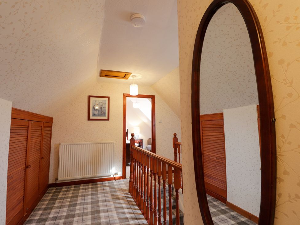 A hallway with a staircase and a mirror at Seascape in Portknockie