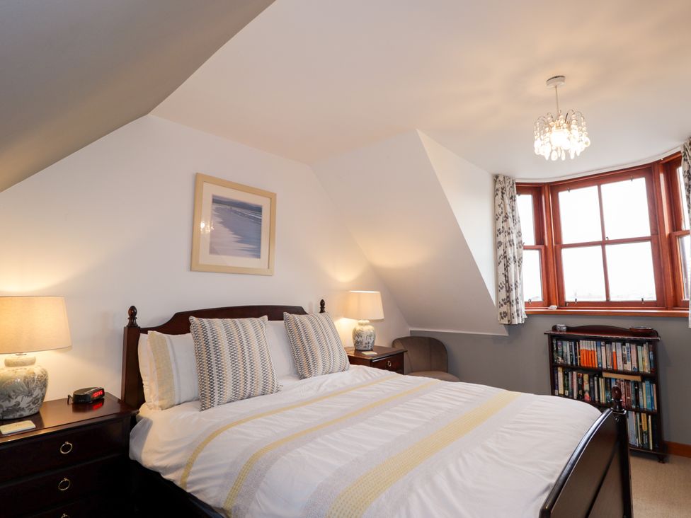 A bedroom with a bed and bookshelf at Seascape in Portknockie