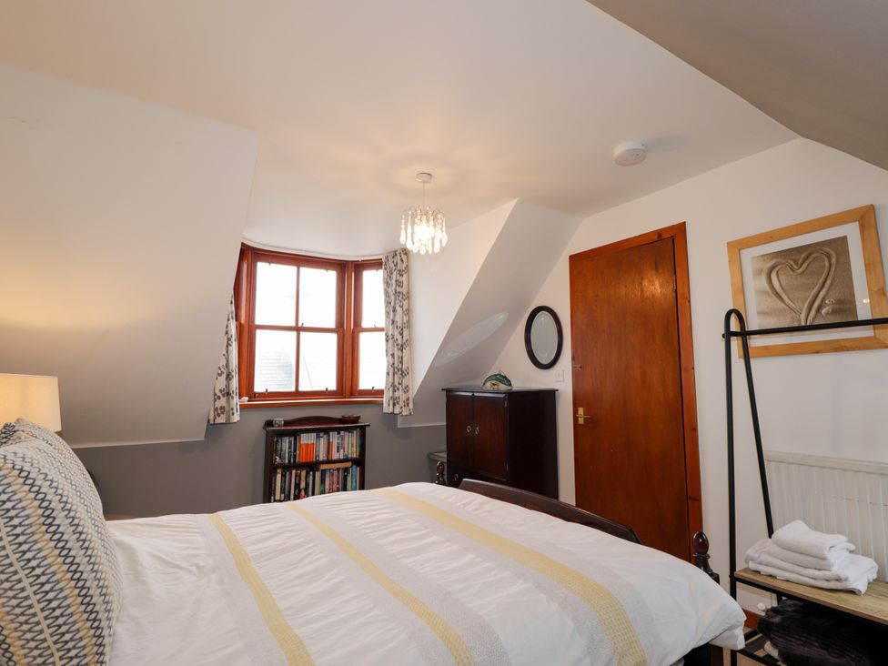A bedroom with a bed and bookshelf at Seascape in Portknockie