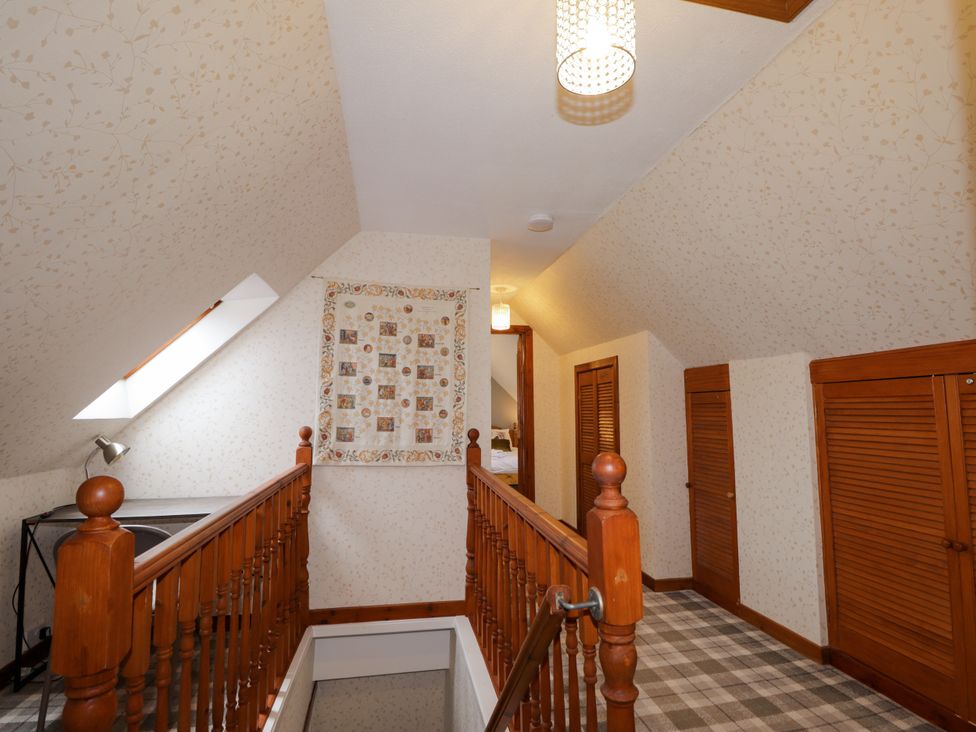 A landing area with a staircase and skylight at Seascape in Portknockie