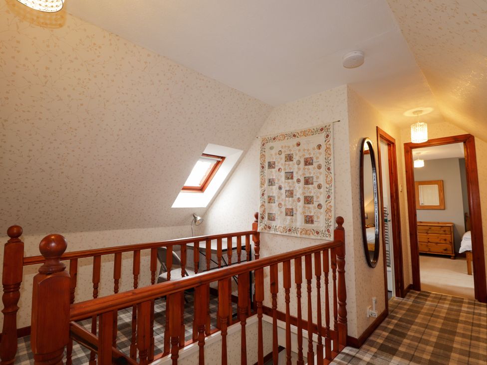 A hallway with a staircase and a quilt at Seascape in Portknockie