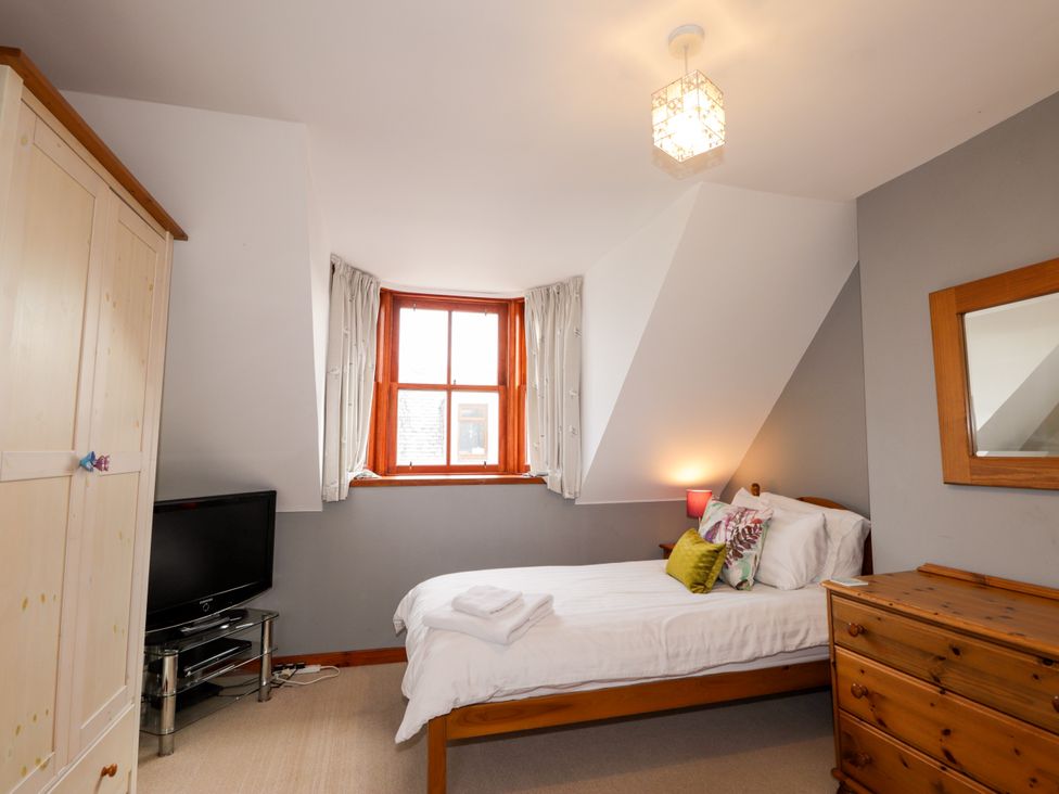 A bedroom with a bed and a tv at Seascape in Portknockie