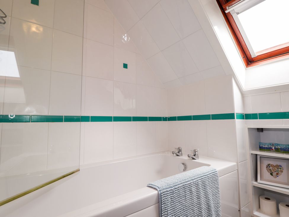 A bathroom with a bathtub and window at Seascape in Portknockie