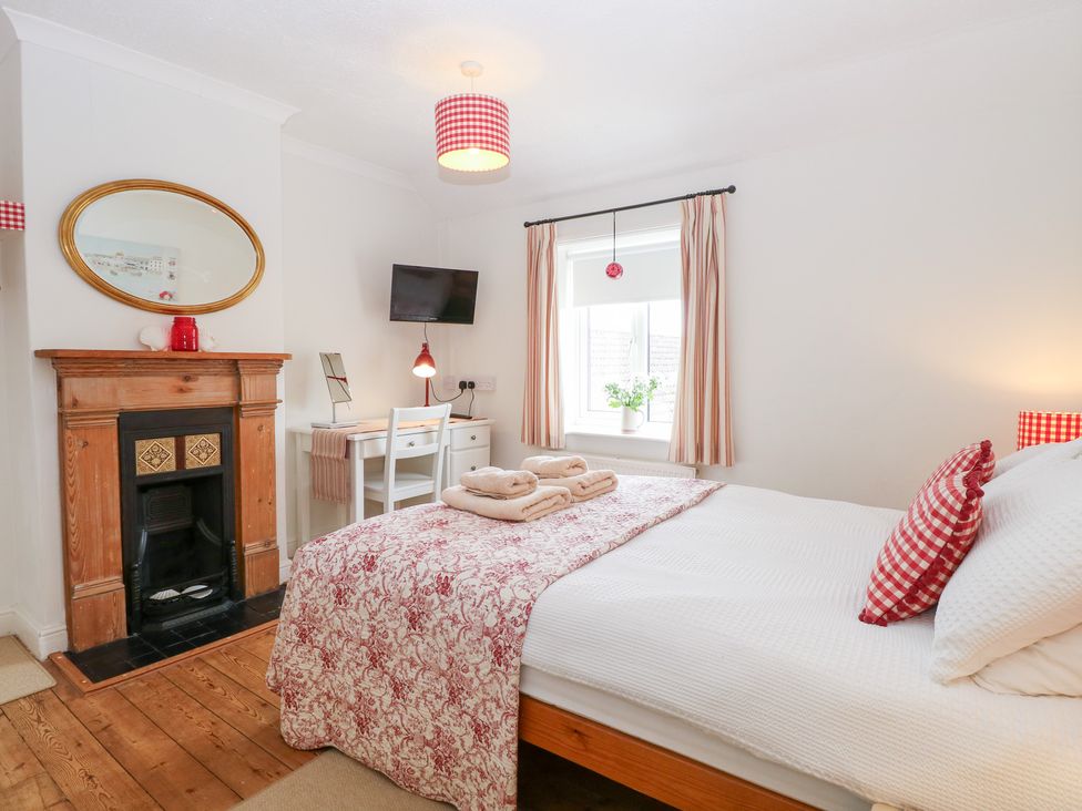 A bedroom with a bed and desk at Driftwood Cottage in Heacham