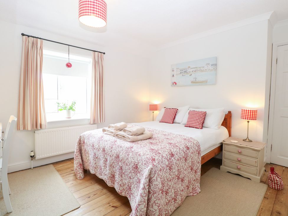 A bedroom with a bed and bedside lamps at Driftwood Cottage in Heacham