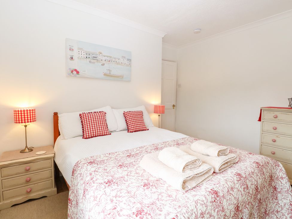 A bedroom with a bed and bedside lamps at Driftwood Cottage in Heacham