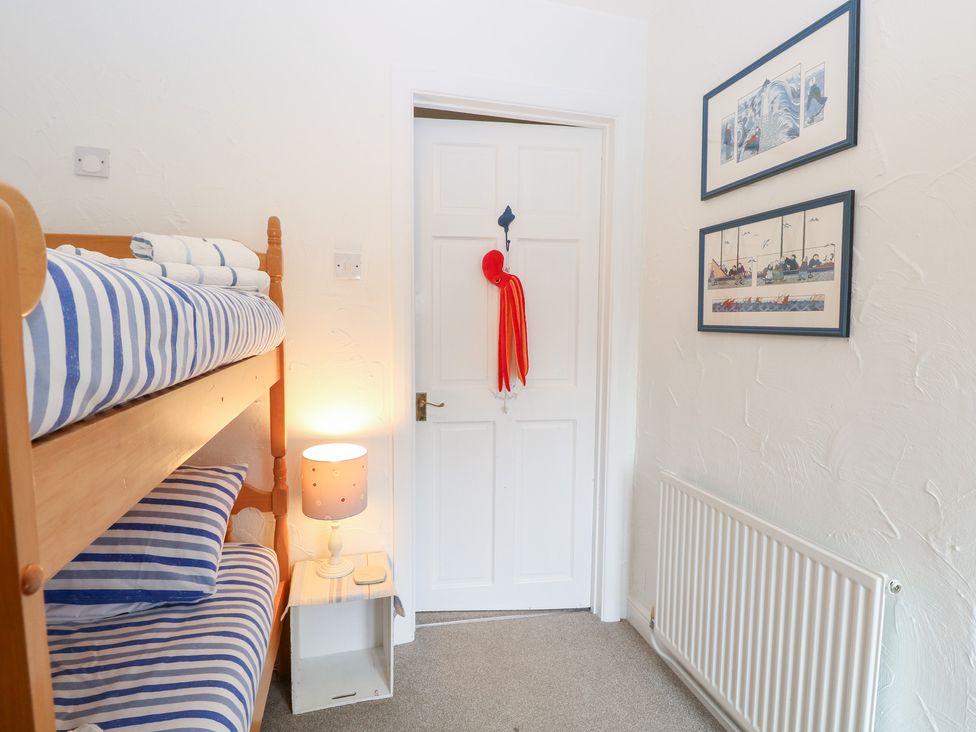 A bedroom with a bunk bed and lamp at Driftwood Cottage in Heacham