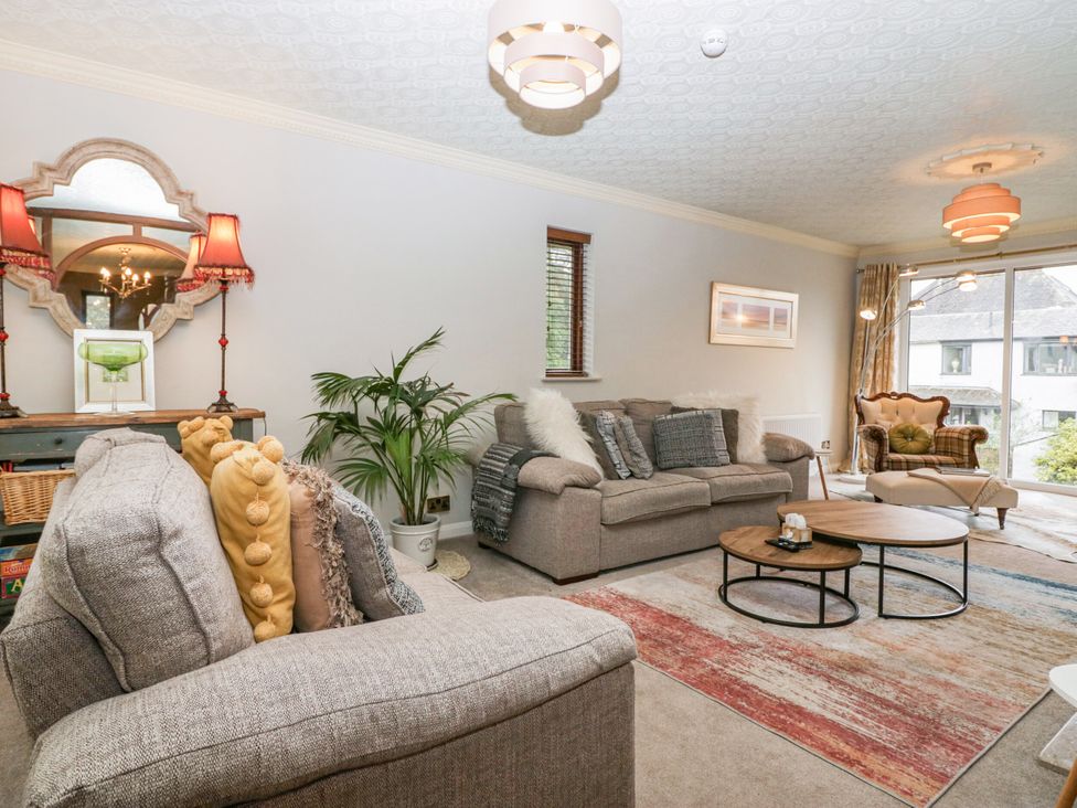 A living room with a sofa, coffee table, and lamp at Kempton in Bowness-on-Windermere