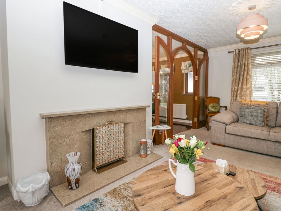 A living room with a TV mounted on the wall at Kempton in Bowness-on-Windermere
