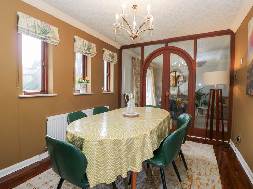 A dining room with a round table and chairs at Kempton in Bowness-on-Windermere