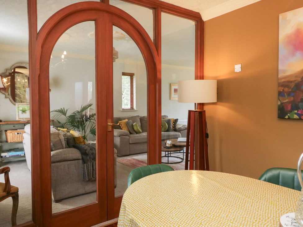 A dining room with a table and lamp at Kempton, Bowness-on-Windermere