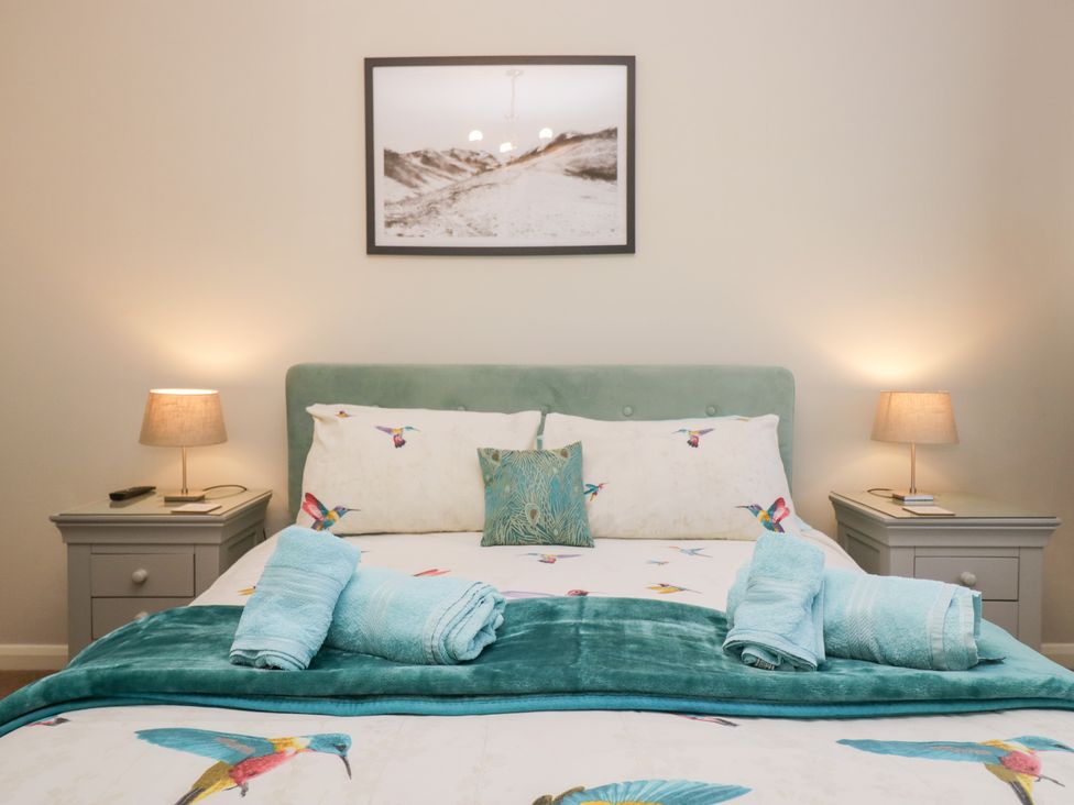A bedroom with a bed and bedside tables at Kempton in Bowness-on-Windermere