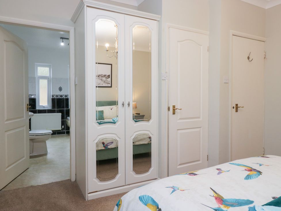 A bedroom with a wardrobe and bathroom access at Kempton in Bowness-on-Windermere