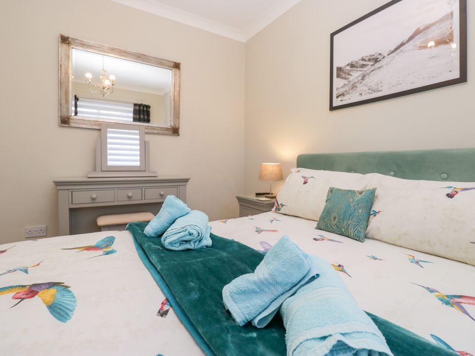 A bedroom with a bed and mirror at Kempton in Bowness-on-Windermere