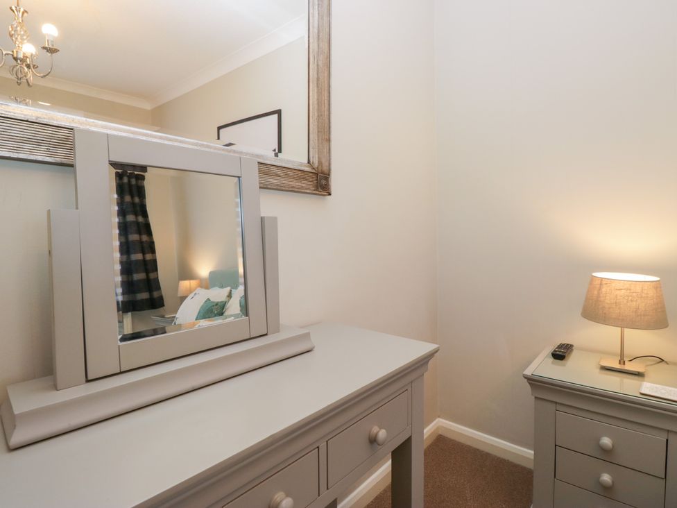 A bedroom with a vanity table and a lamp at Kempton in Bowness-on-Windermere
