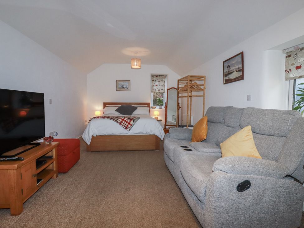 A bedroom with a bed and sofa at Bramble Barn Inches near Lanivet