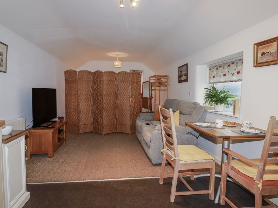 A living room with a sofa and dining table at Bramble Barn Inches near Lanivet
