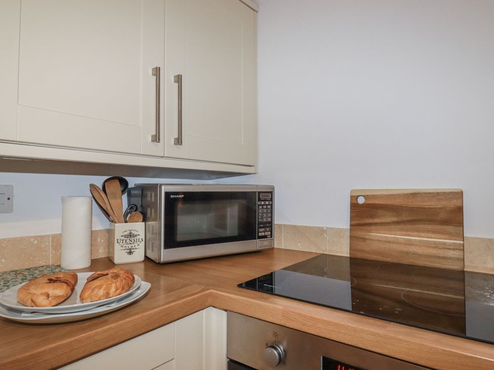A kitchen with a microwave and pastries on the counter at Bramble Barn Inches near Lanivet