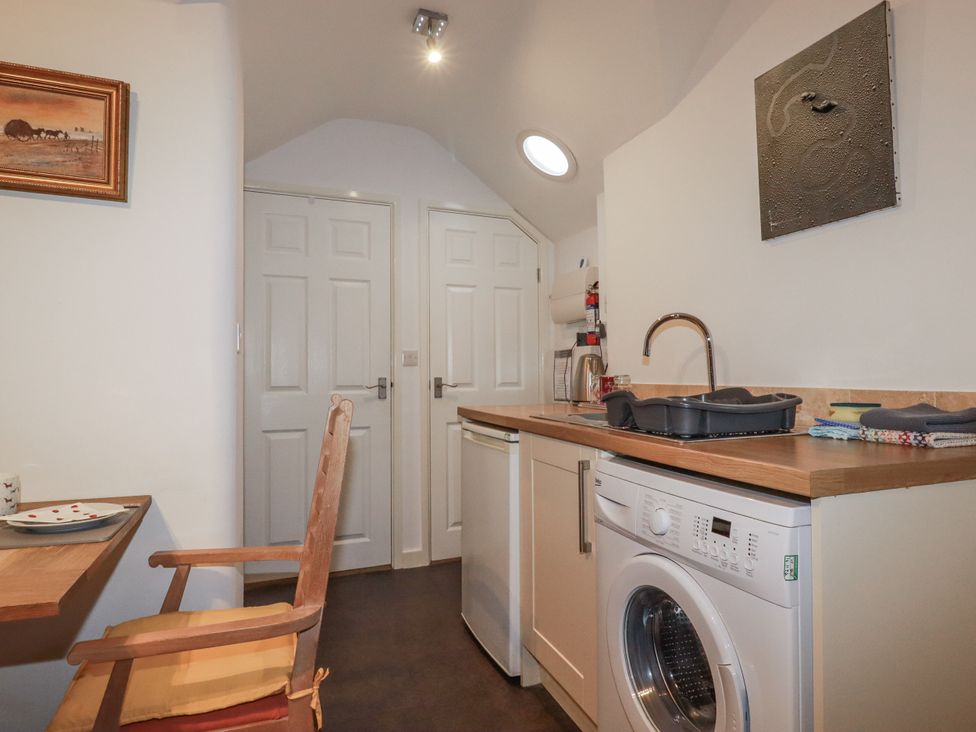 A kitchen with a washing machine and sink at Bramble Barn Inches near Lanivet