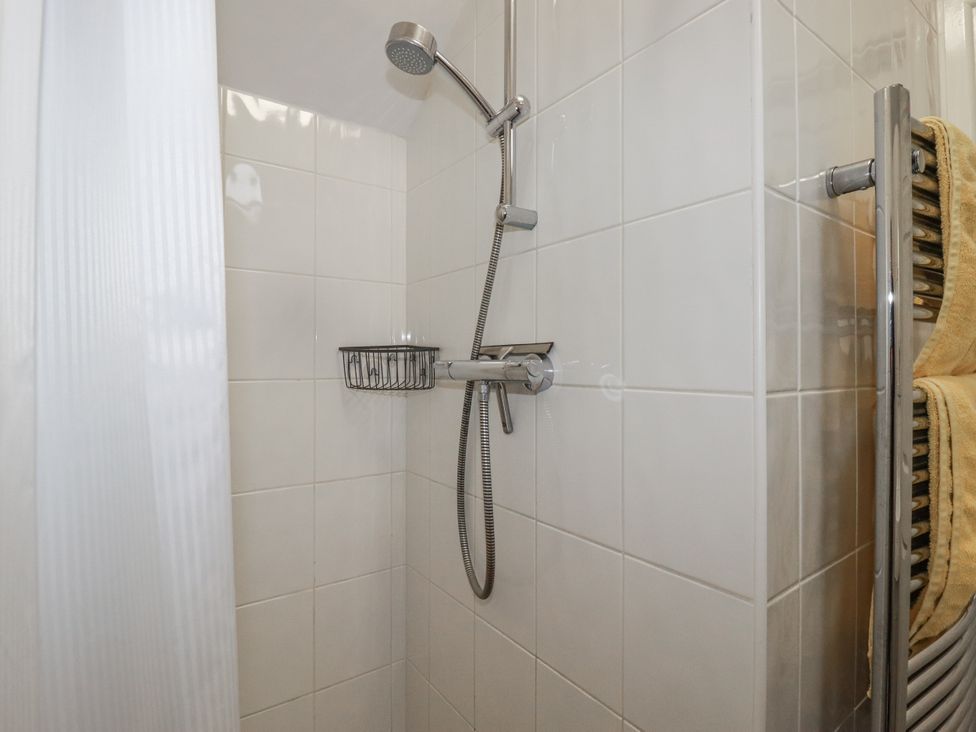 A shower area with a showerhead and towels at Bramble Barn Inches near Lanivet